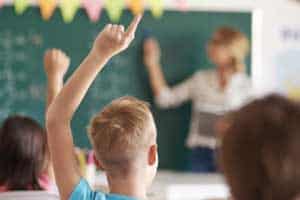 kid raising hand at school